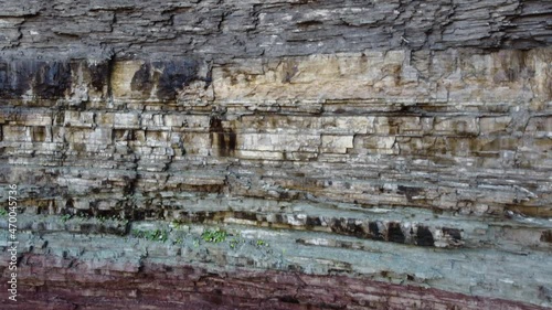 geological rock strata, colored stratified rock layers in the escarpment. descending aerial view photo