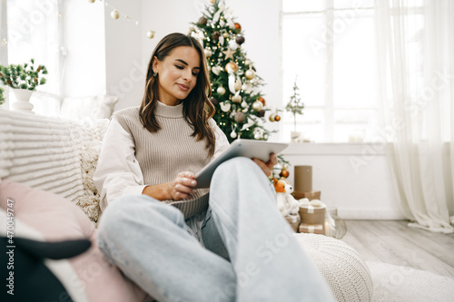 Beautiful woman relaxing on the sofa with digital tablet at Christmas © fotofabrika
