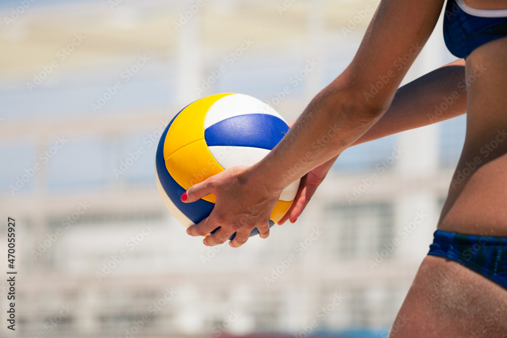 Beach volleyball player, playing summer. Woman holding a beach volley ball in hand.