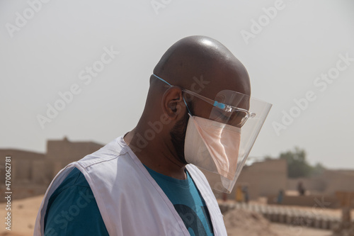 Medical worker using protective transparent mask, combined with medical mask, during pandemic situation  photo