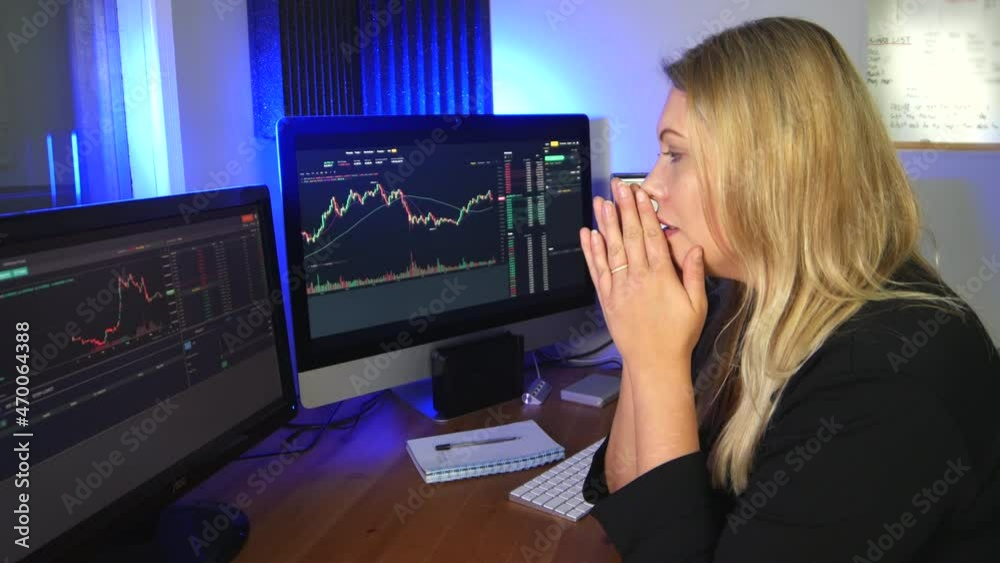 Worried stock trader looking at a crash on the charts. The blonde woman is stressed while trading forex and cryptocurrency.