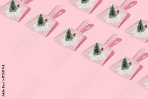 Christmas trees and snow in dustpans pattern on pastel pink background. Winter creative idea. Retro aesthetic christmas minimal concept.