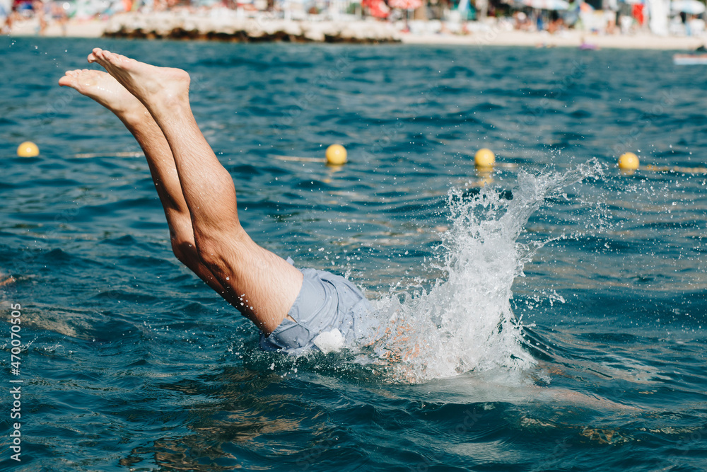 Guy jumping in the water headfirst to swim in Croatia