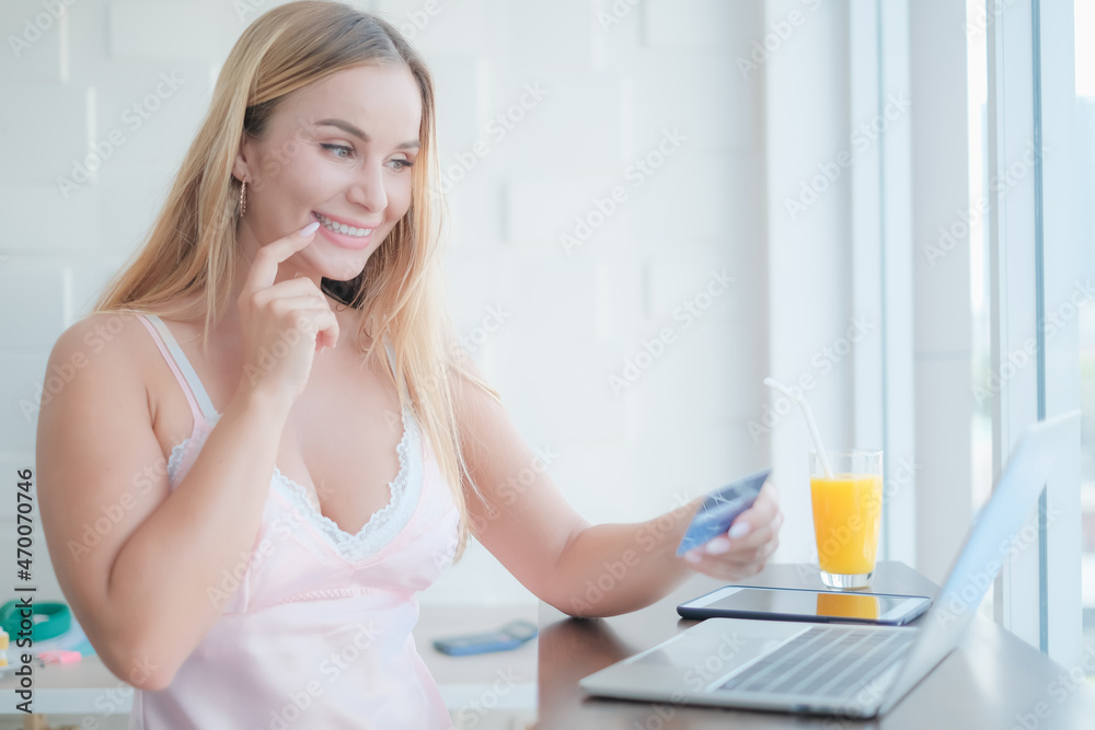 caucasian woman playing laptop with credit card in morning caucasian woman playing laptop with credit card in morning