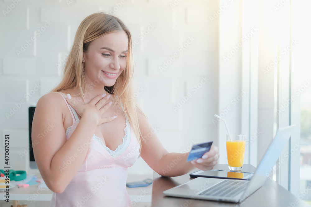 caucasian woman playing laptop with credit card in morning caucasian woman playing laptop with credit card in morning