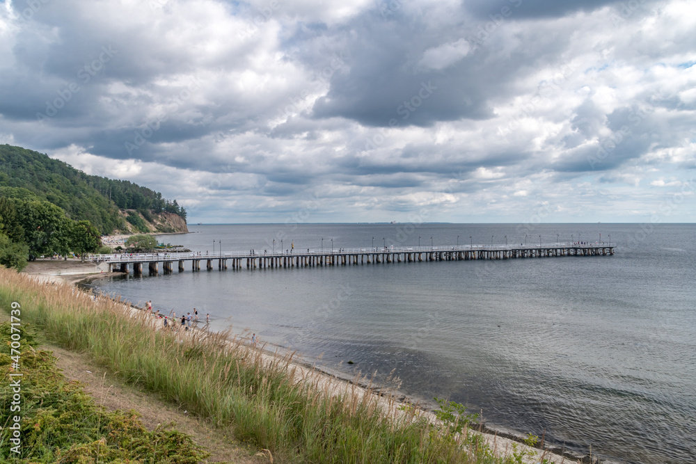Fototapeta premium Wooden pier on Baltic Sea in Gdynia Orlowo at cloudy summer day.