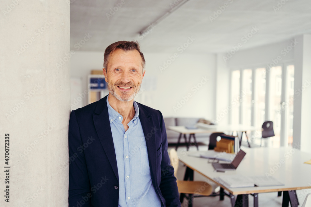 Senior businessman standing grinning at the camera Senior businessman standing grinning at the camera
