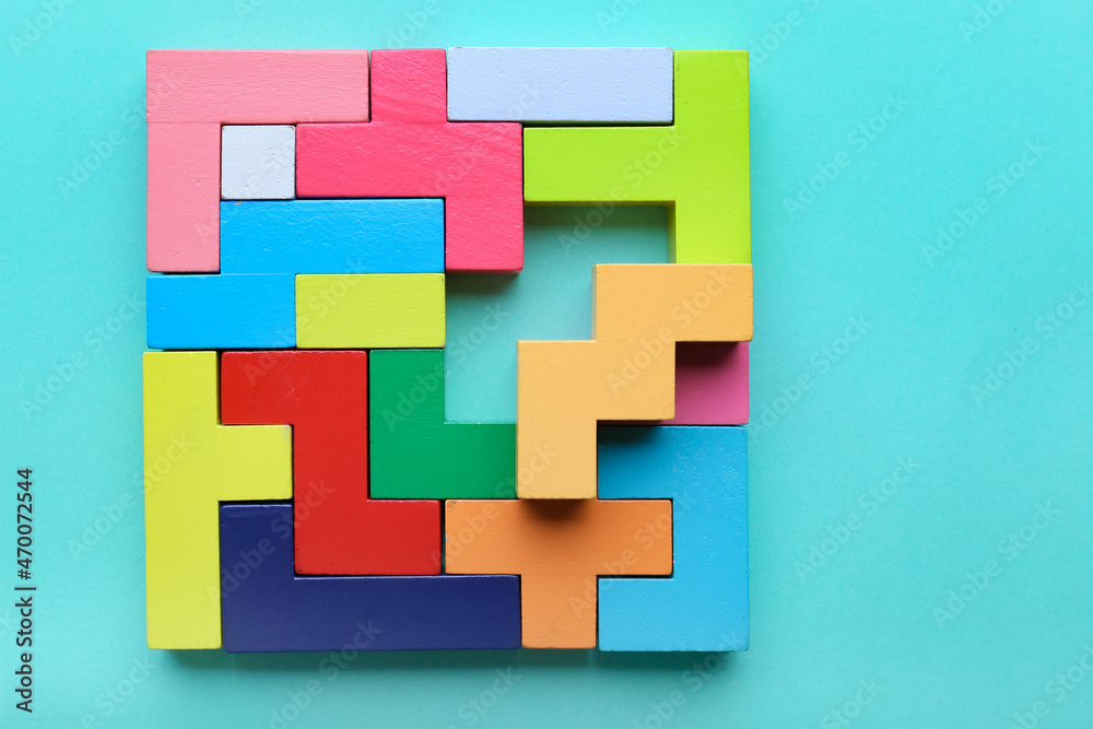 Multicolored puzzle, hand and cubes on a mint background - obrazy, fototapety, plakaty 
