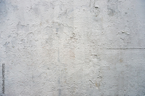 Old light grey concrete wall background. Many layers of exfoliating paint. 