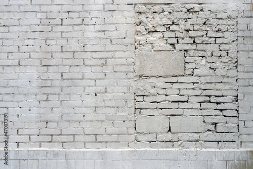 A brick light gray or white wall with a bricked-up passage in a hurry
