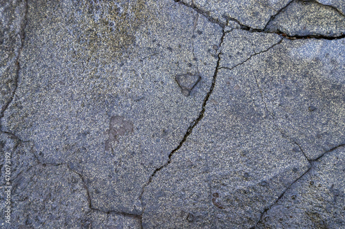The concrete masonry has cracked as a result of bad weather conditions over many years. Wet cracked stone. 