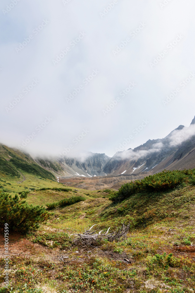 Beautiful landscape of the Kamchatka Peninsula: summer panoramic view of the Vachkazhets mountain range. Far East of Russia, Kamchatka Territory. Beautiful landscape of the Kamchatka Peninsula: summer panoramic view of the Vachkazhets mountain range. Far East of Russia, Kamchatka Territory.