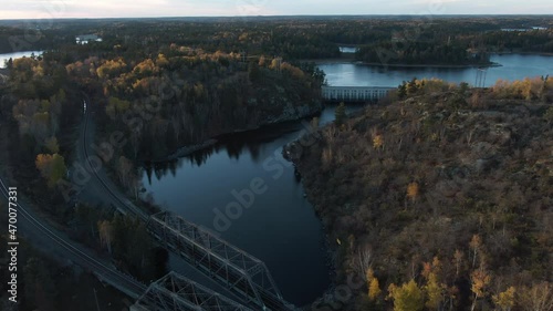 Aerial scenic shot of train tracks, bridge, power lines, and hydro dam in Kenora Ontario photo