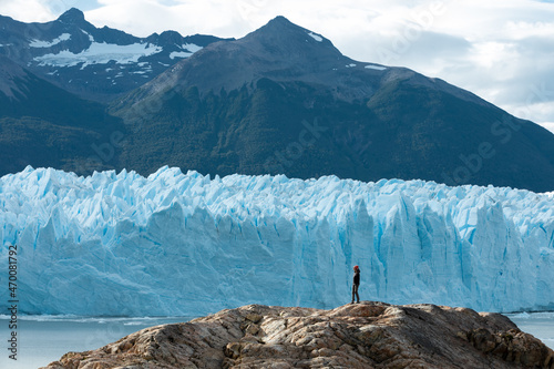 A woman standing on the rock formation and looking at the Perito Moreno Glacier