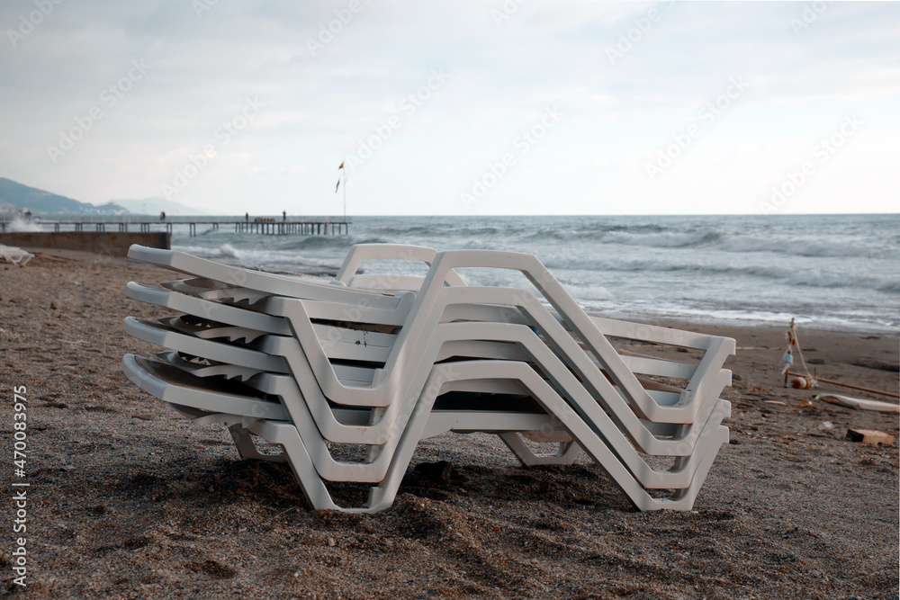 stacked sun loungers on the beach, bad weather stacked sun loungers on the beach, bad weather
