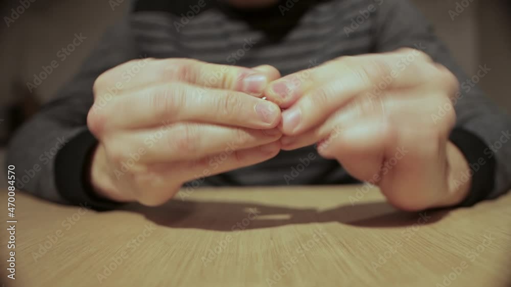 A man twists a candy wrapper in his hands and throws it out, close-up A man twists a candy wrapper in his hands and throws it out, close-up