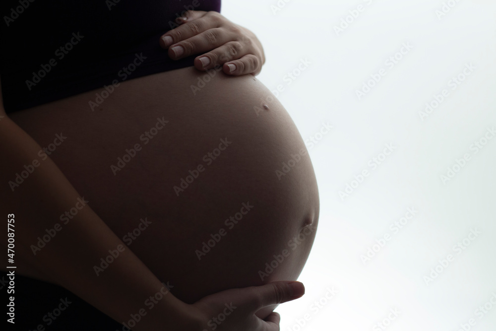 silhouette of pregnant woman's belly with hands touching it on white isolated background, new life concept silhouette of pregnant woman's belly with hands touching it on white isolated background, new life concept