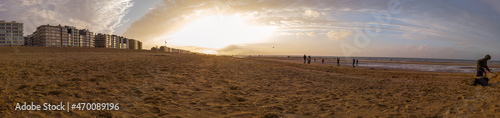 Lowangle panorama of the beach of Sint-idesbald with a lot of sand in the foreground in autumnal evening light