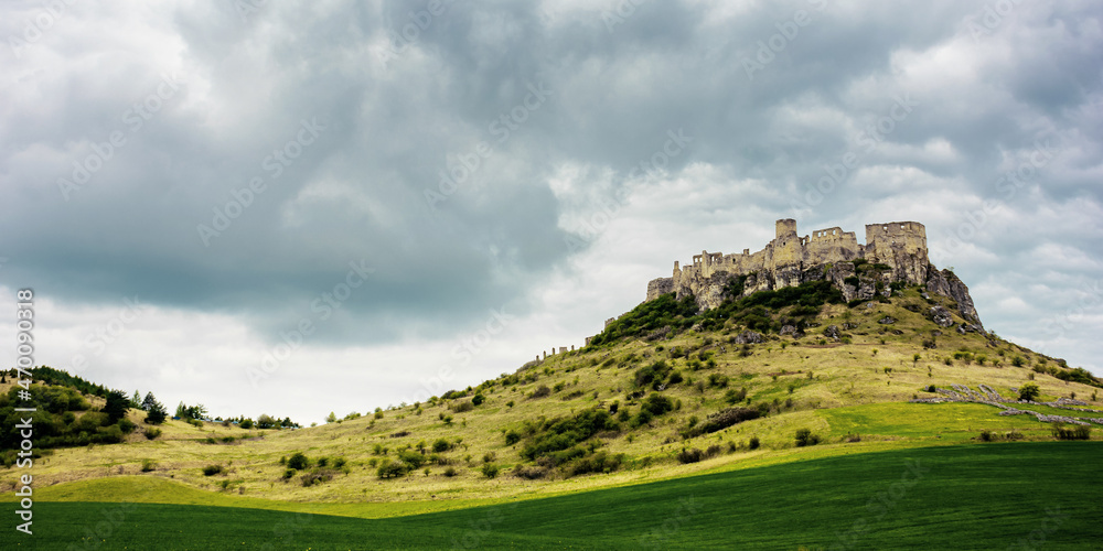 spis, slovakia - 29 APR 2019: castle ruins on the hill. grassy meadow in the foreground. popular travel destination on a cloudy day