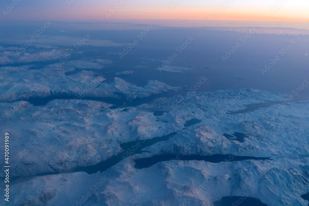 Fototapeta premium Aerial view on snow covered mountains and glaciers in Greenland coastal area