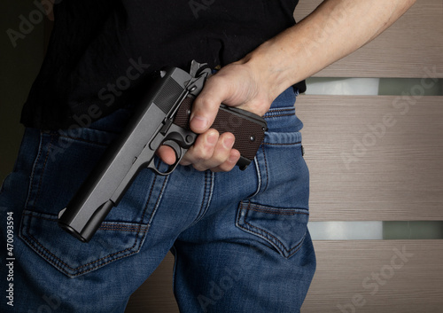 Man holding hidden short gun in his hand. 
