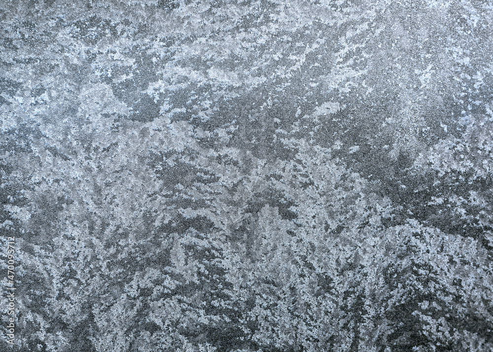 Frosty pattern on the window pane. Frozen water droplets formed a beautiful pattern. The window glass is covered with a winter pattern. Frosty pattern on the window pane. Frozen water droplets formed a beautiful pattern. The window glass is covered with a winter pattern.
