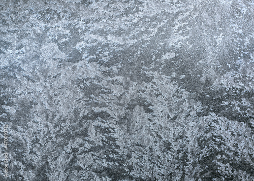Frosty pattern on the window pane. Frozen water droplets formed a beautiful pattern. The window glass is covered with a winter pattern. © Сергей Брызгалов