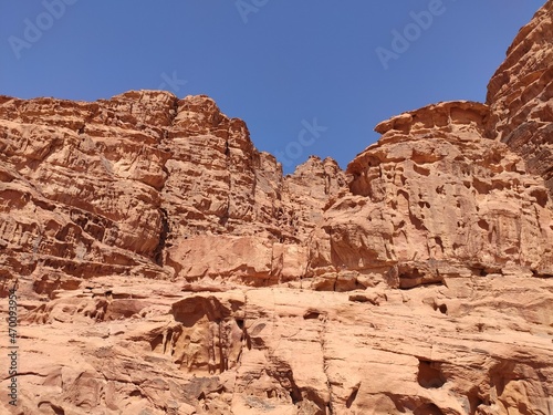 Dans la zone protégée du désert de Wadi Rum en Jordanie, avec de hautes montagnes rocheuses, exploration dans l'inconnu, sous un soleil et forte chaleur, escalade, faille ou crevasse rocheuse