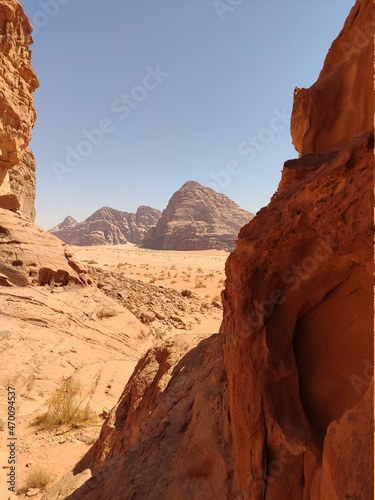 Dans la zone protégée du désert de Wadi Rum en Jordanie, avec de hautes montagnes rocheuses, exploration dans l'inconnu, sous un soleil et forte chaleur, escalade, abri dans l'ombre, pour se reposer