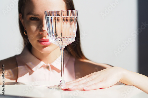 Conceptual surreal portrait Caucasian woman looking through glass of water