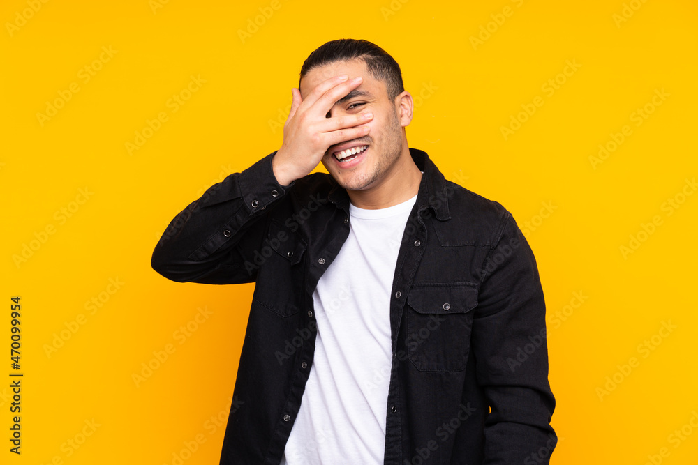 Asian handsome man isolated on yellow background nervous stretching hands to the front Asian handsome man isolated on yellow background nervous stretching hands to the front