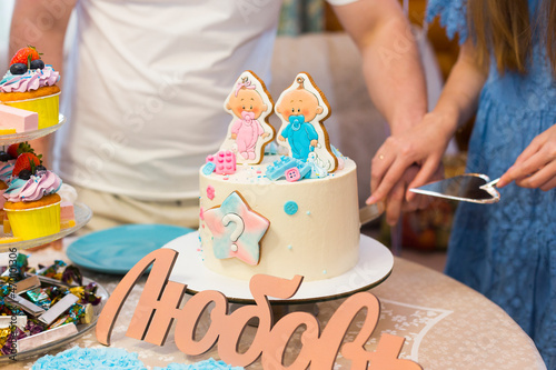 Future or prospective parents are cutting  blue and pink festive cake at gender party to know boy or girl