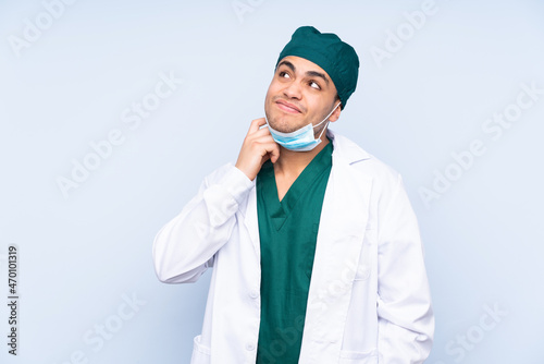 Surgeon man with uniform isolated on blue background thinking an idea