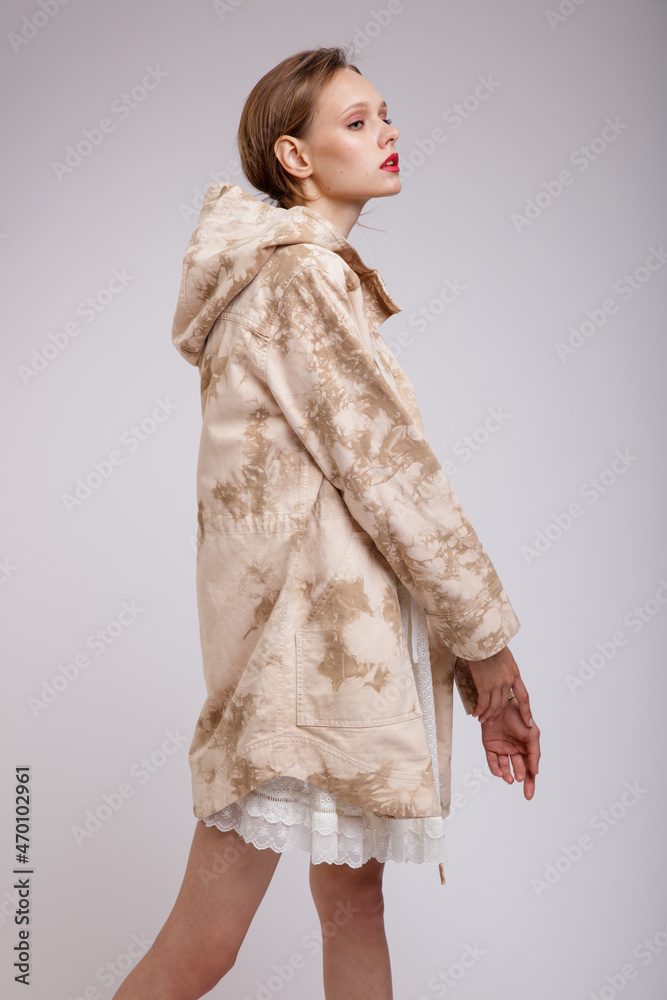 High fashion photo of a beautiful elegant young woman in a pretty jacket with beige streaks, white dress posing over soft gray background. Slim figure. Studio shot High fashion photo of a beautiful elegant young woman in a pretty jacket with beige streaks, white dress posing over soft gray background. Slim figure. Studio shot