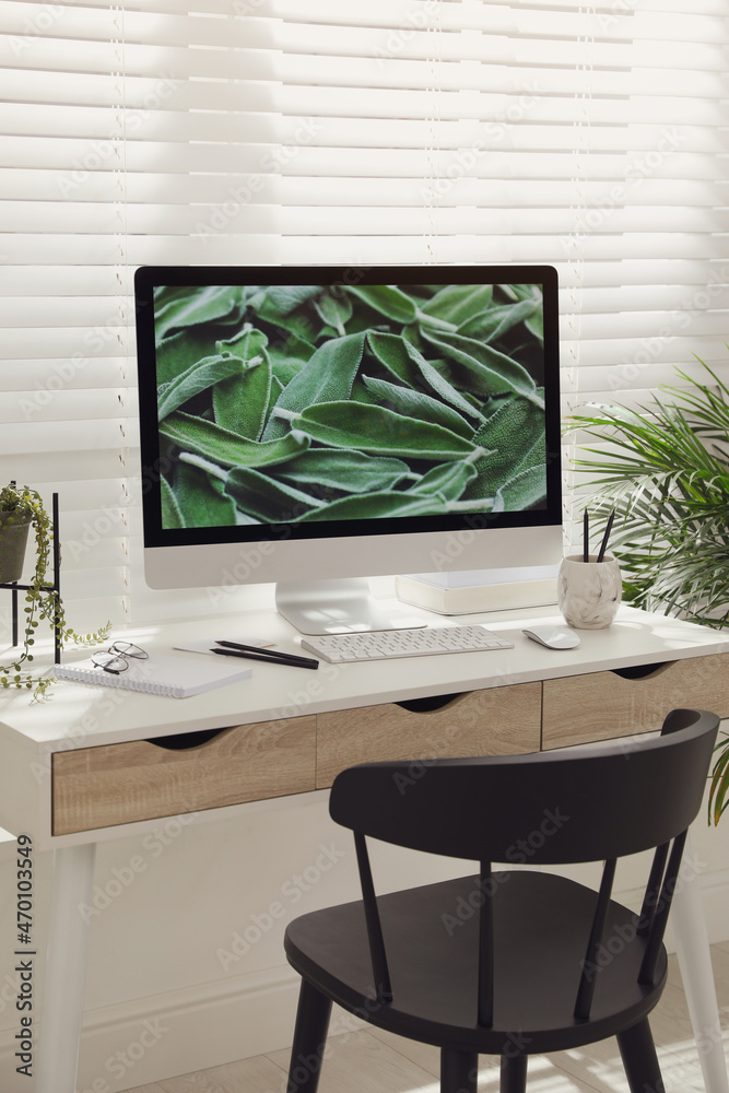 Comfortable workplace with modern computer and green plant in room. Interior design Comfortable workplace with modern computer and green plant in room. Interior design