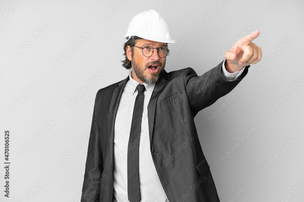 Young architect man with helmet over isolated background pointing away Young architect man with helmet over isolated background pointing away