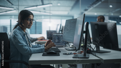 Diverse Office: Indian IT Programmer Working on Desktop Computer. Female Specialist Creating Innovative Software Engineer Developing App, Program, Video Game. Terminal with Coding Language.