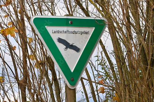 Landschaftsschutzgebiet, nature preserve area in Germany. Green sign with black eagle indicating a landscape reserve. Symbol for German landscape protection area. photo