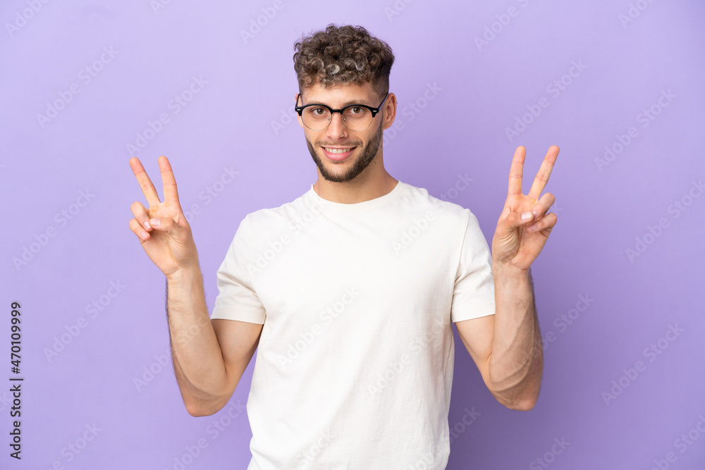 Delivery caucasian man isolated on purple background showing victory sign with both hands Delivery caucasian man isolated on purple background showing victory sign with both hands