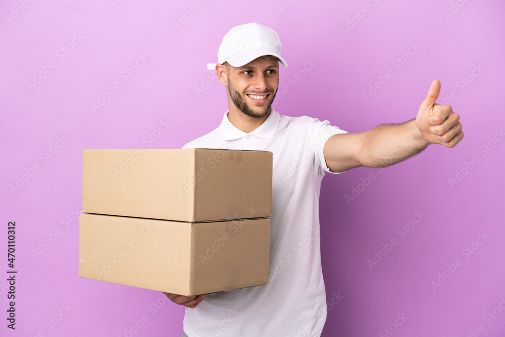 Delivery caucasian man isolated on purple background giving a thumbs up gesture Delivery caucasian man isolated on purple background giving a thumbs up gesture