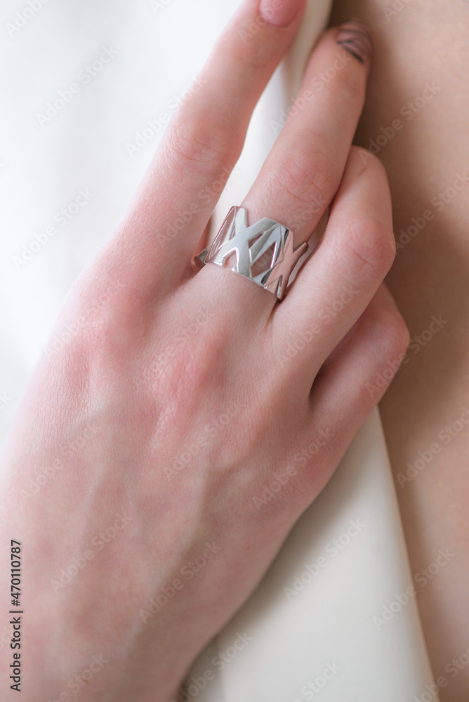 Trending silver ring with pearls on a beautiful young girl in a white fashionable jacket. Beauty and fashion Trending silver ring with pearls on a beautiful young girl in a white fashionable jacket. Beauty and fashion