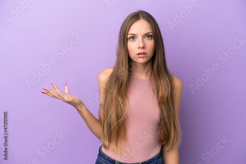 Young Lithuanian woman isolated on purple background making doubts gesture