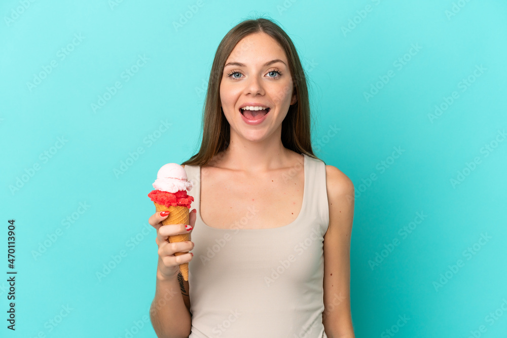 Young Lithuanian woman with cornet ice cream isolated on blue background with surprise facial expression Young Lithuanian woman with cornet ice cream isolated on blue background with surprise facial expression