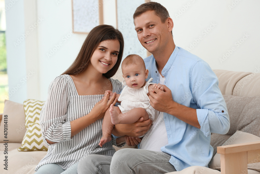 Portrait of happy family with their cute baby at home