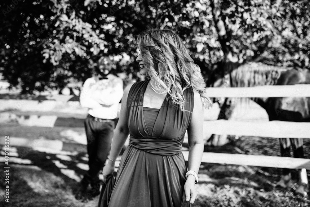 A loving couple on a date. Horseback riding. Purple dress. Black and white photo. A loving couple on a date. Horseback riding. Purple dress. Black and white photo.