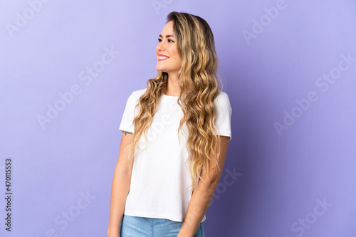 Young Brazilian woman isolated on purple background looking side
