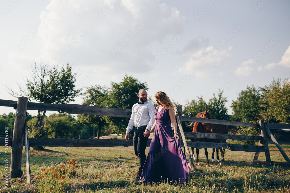 A loving couple on a date. Horseback riding. Purple dress.