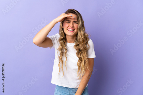 Young Brazilian woman isolated on purple background looking far away with hand to look something