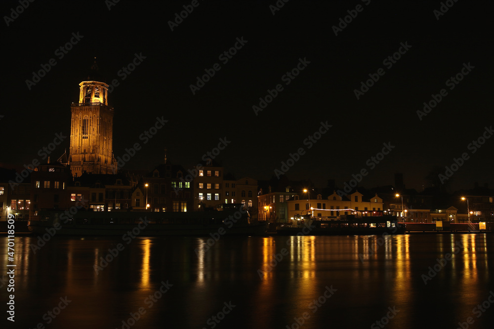 The Great Church and buildings in the City of Deventer, the Netherlands, at night with reflection in the water
