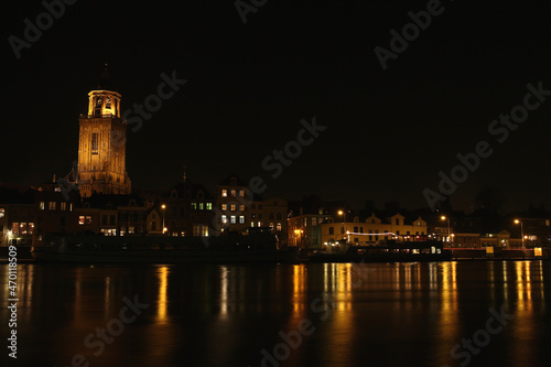 The Great Church and buildings in the City of Deventer, the Netherlands, at night with reflection in the water
